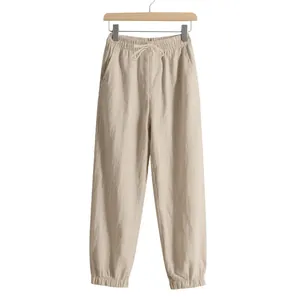 Detailed view of men's beige linen jogger pants featuring a drawstring waist and elastic cuffs