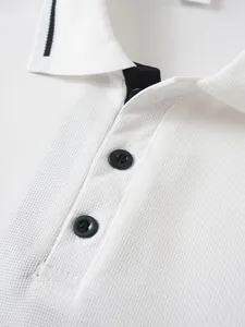Close-up macro detail of white jacquard polo shirt collar with stylish black buttons
