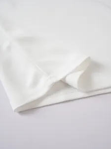 Close-up of white jacquard Polo shirt hem showing high-quality stitching and fabric texture