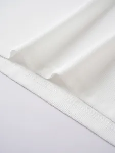 Close-up of white jacquard knit fabric and hem stitching on men's polo shirt