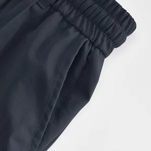 Macro view of men's business casual pants featuring elastic waist and side pocket details.