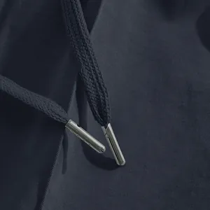 Close-up detail of metal-tipped drawstrings on men's slim fit casual navy pants
