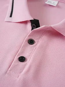 Close-up of pink men's polo shirt featuring jacquard texture and black buttons