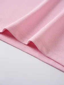 Macro view of pink breathable jacquard fabric texture on a premium men's short sleeve polo