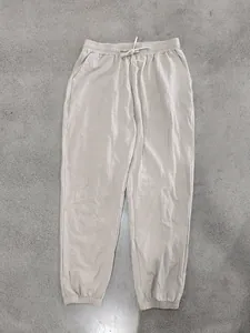 Detail view of men's casual beige linen jogger pants featuring a drawstring waist