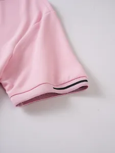 Macro view of a pink jacquard men's polo shirt sleeve detailing the woven fabric texture.