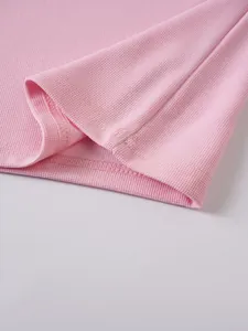Macro close-up showing the pink jacquard fabric texture and neat stitching of a polo shirt