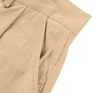 Gros plan détaillé du pantalon en lin beige montrant la poche et la texture du tissu