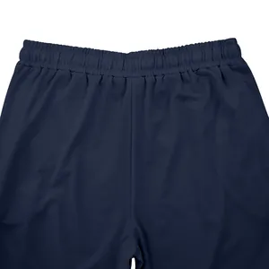 Detailed macro view of the elastic waistband on navy blue men's sports joggers.