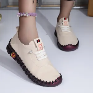 Détail de chaussures plates confortables en cuir souple crème pour femmes avec semelle cousue main.
