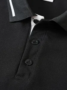 Detailed close-up of a premium black jacquard polo shirt showing buttons and collar