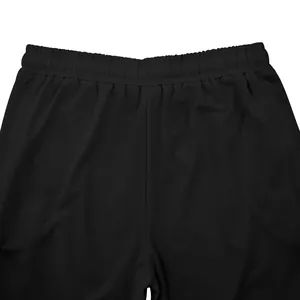 Close-up detail of the elastic waistband on men's solid black loose fitness sweatpants