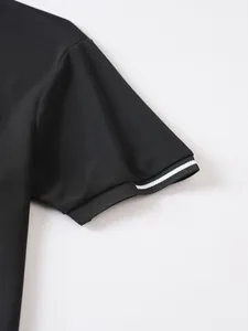Macro detail of black men's polo shirt sleeve with white stripe on ribbed cuff