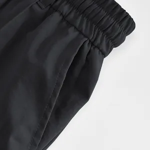 Close-up of the elastic waistband and pocket stitching on black men's casual trousers