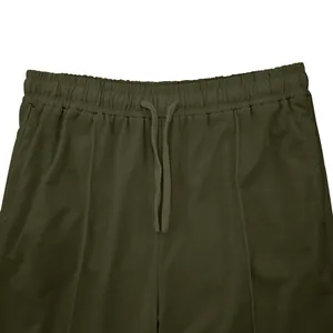 Close-up of the elastic waistband and drawstring detail on olive green men's joggers.