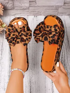 Primer plano de sandalias de plataforma con estampado de leopardo, lazo y suela naranja