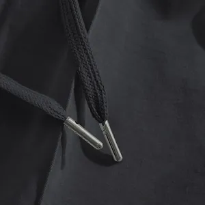 Close-up detail of drawstring with metal aglets on men's slim fit casual chino pants