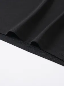 Close-up detail of black jacquard polo shirt hem showing fine stitching and fabric texture