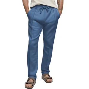 Detailed view of men's blue straight-leg sweatpants featuring a drawstring waist and seam.
