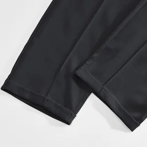Close-up detail of the cuffed hems of men's slim-fit business casual trousers