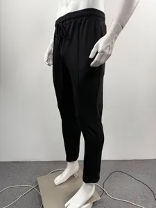 Detail view of men's black solid color sweatpants on a mannequin with drawstring waist.