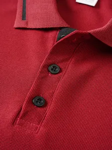 Close-up detail of a red jacquard polo shirt showing fabric texture and buttons