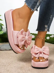 Detalle de sandalias de plataforma rosa con lazo grande y suela con textura de moda