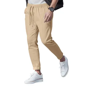 Detail view of men's slim fit khaki tapered casual pants with a drawstring waist.