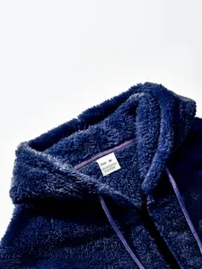 Nahaufnahme eines dicken dunkelblauen doppelseitigen Fleece-Hoodies mit Etikett