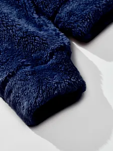 Nahaufnahme zeigt die Textur des marineblauen, dicken, doppelseitigen Fleece-Stoffs am Ärmel.