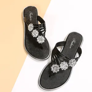 Chanclas negras con flores de pedrería plateada y letras de moda elegantes.