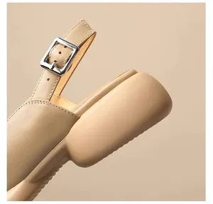 Close-up detail of the adjustable buckle strap and thick platform sole on beige sandals.