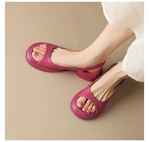Close-up view of stylish pink platform open-toe sandals with chunky heels on model