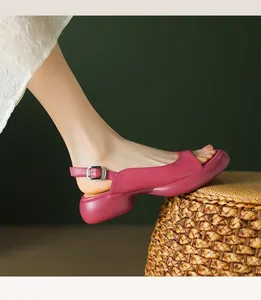 Detailed side view of magenta platform peep-toe sandals with buckle strap on a foot