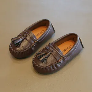 Nahaufnahme der Textur und Quasten dieser braunen Leder-Slipper für Kinder mit weicher Sohle.