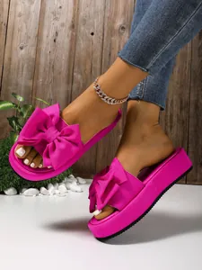 Sandalias de plataforma fucsia con detalle de lazo grande para un estilo veraniego
