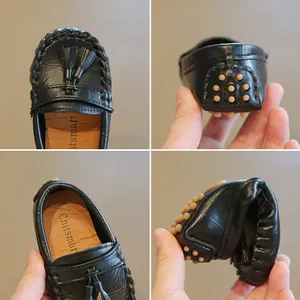 Detailansicht der flexiblen schwarzen Leder-Kinderslipper mit dekorativen Quasten