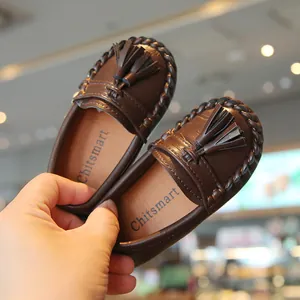 Detaillierte Makroansicht dunkelbrauner Kinder-Loafer mit Quastendekor und weicher Sohle