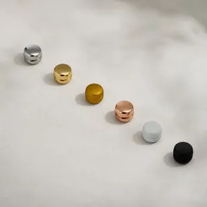 Seis clips magnéticos para bufandas en varios acabados metálicos sobre tela gris