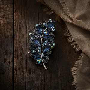 Vista detallada del broche de hoja de cristal con diamantes de imitación azules.