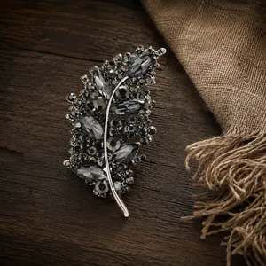 Vista macro de un elegante broche de hoja con cristales grises sobre un fondo madera rústica