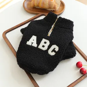 Detail view of black sherpa pet jacket with ABC embroidery and half-zipper design.