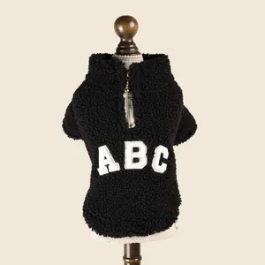 Close-up of a warm black fleece pet jacket with a zipper and white ABC patch detail.