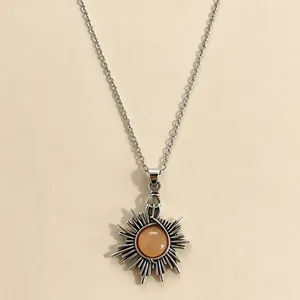 Detailed close-up of a vintage sun pendant necklace featuring a round amber moonstone.