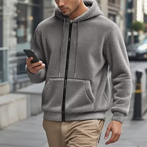 Mann trägt eine dicke graue doppelseitige Fleecejacke mit Kapuze und Reißverschluss