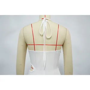 Detailansicht der Rückseite eines weißen Neckholder-Bodysuits mit Cut-out und Ring.