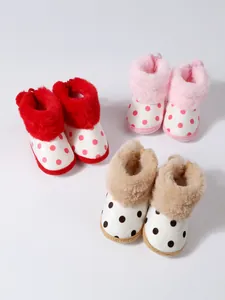 Makroansicht von weichen Baby-Winterschuhen mit Punkten und flauschigem Kunstfellbesatz