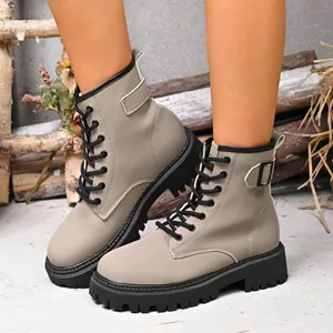 Dettaglio di stivaletti stringati grigi da donna con spessa suola platform nera stile.