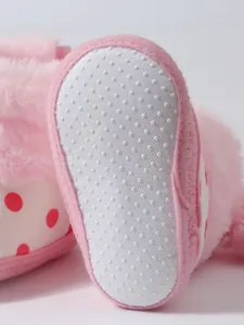 Detailansicht der weißen rutschfesten Weichsohle an rosa flauschigen Winter-Babystiefeln