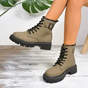 Vista dettagliata di stivaletti Martin kaki con suole platform e fibbie nere chic.